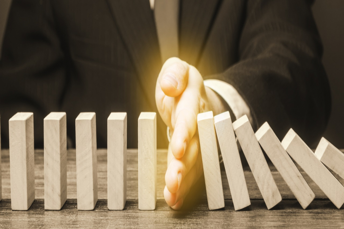 Businessman stops domino falling. Strategy development. Debt restructuring. Risk management concept. Successful strong business and problem solving. Reliable leader. Stop the destructive processes.