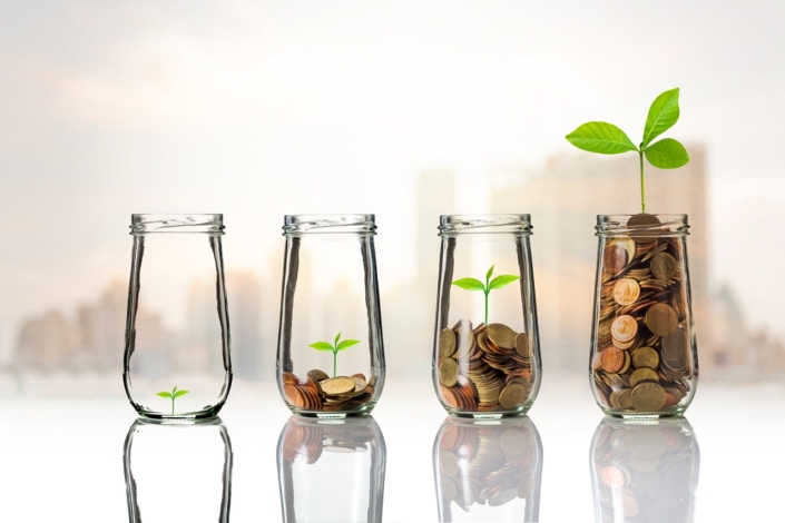 Gold coins and seed in clear bottle on cityscape photo blurred c