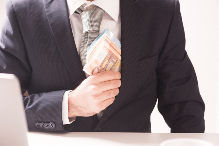 Businessman putting money in his pocket