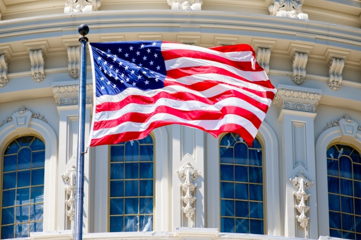 The American Flag waves in fron of the Capitol building in Washi